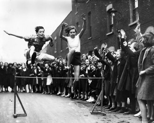 11. 8th May 1936: East London Schools Hurdles champion Grace Adams racing on the Poplar street track in preparation for the annual contest.