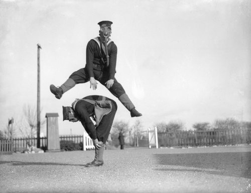 13. Able seamen at the Royal Navy Anti-Gas School at Tipnor, Portsmouth play leapfrog wearing gas masks, to accustom them to carrying out strenuous tasks in respirators. 22nd January 1934.